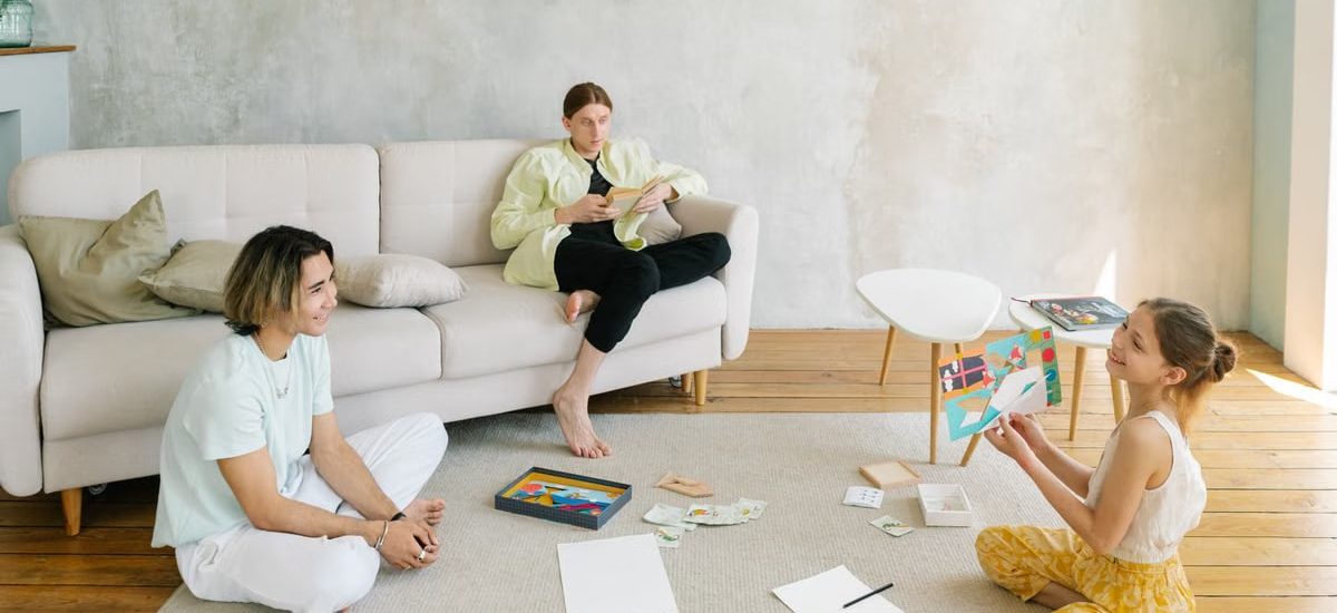 A family enjoying creative activities together in a bright living room setting.