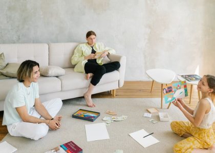 A family enjoying creative activities together in a bright living room setting.